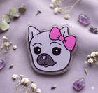 Sticker of a dog with a pink bow on a purple background with flowers and crystals